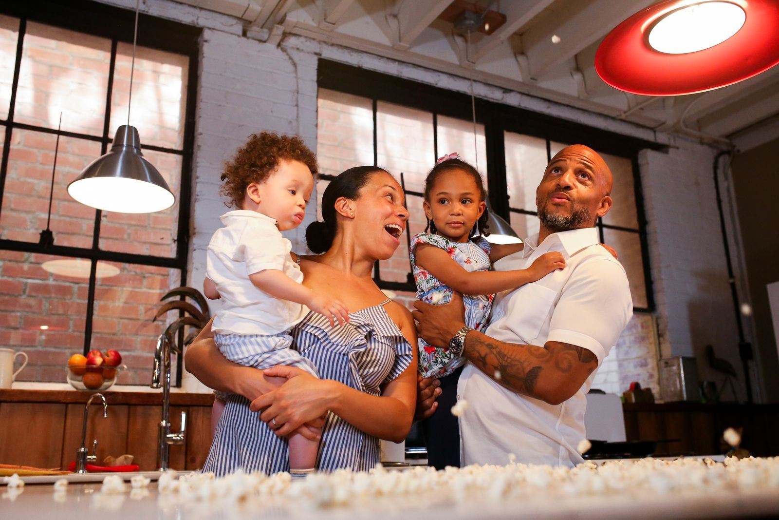 A family laughing together at home in their kitchen.